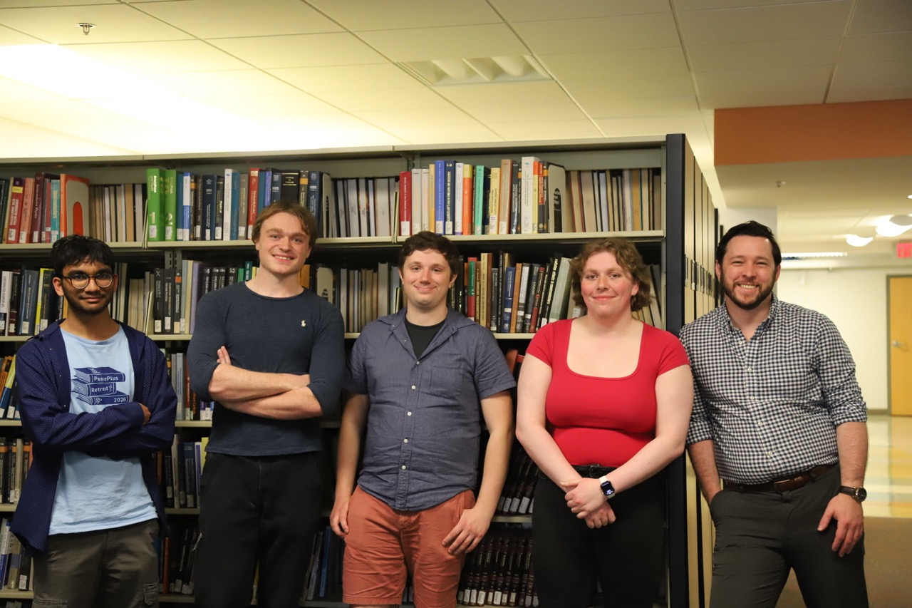BQIS group members standing in a library aisle